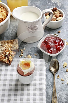 Breakfast time: soft-boiled egg, french croissants, muesli bars, milk