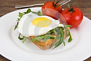 Breakfast toast with fried egg and arugula