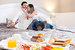 Breakfast tray with couple in background.