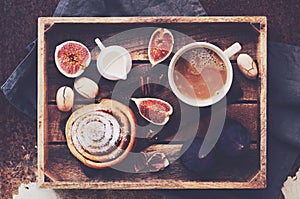 Breakfast tray - cup of coffee with cream, cinnamon roll, fresh figs and pecans