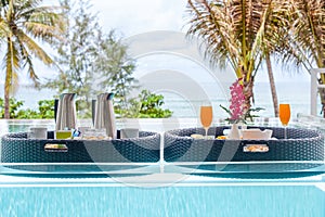 Breakfast tray in infinity swimming pool in resort, floating breakfast in luxury hotel with sea view. Exotic summer