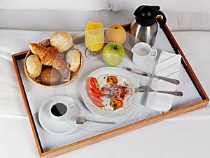 Breakfast tray laying on white bed