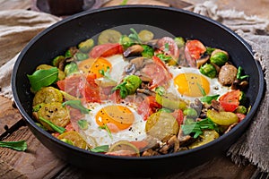 Breakfast for two. Fried eggs with vegetables - shakshuka in a frying pan