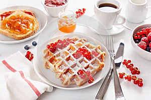 Breakfast with waffle, toast, berry, jam, chocolate spread and coffee