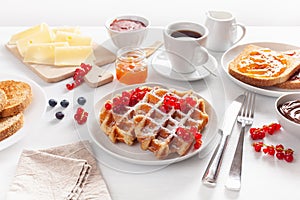 Breakfast with waffle, toast, berry, jam and coffee