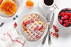 Breakfast with waffle, toast, berry, jam and coffee. Top view