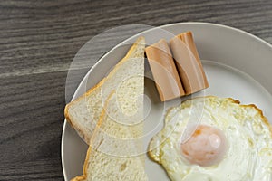 Breakfast on a white plate in the lower right corner on the wooden floor