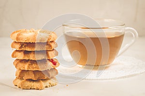 Breakfast whith cookies and glass cup whith tea/Breakfast whith cookies and glass cup whith tea on a white table. Focus on cookies