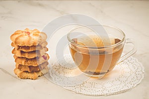 Breakfast whith cookies and glass cup whith tea/Breakfast whith cookies and glass cup whith tea on a white table. Selective focus