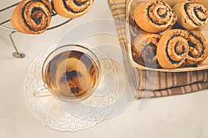 Breakfast whith rolls with poppy and glass cup whith tea/Breakfast whith rolls with poppy and glass cup whith tea. Focus on bread