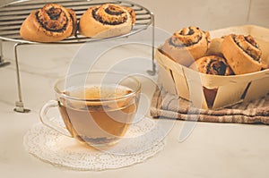 Breakfast whith rolls with poppy and glass cup whith tea/Breakfast whith rolls with poppy and glass cup whith tea. Focus on bread