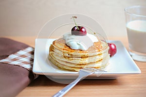 Breakfast whole wheat pancakes with cherry and yogurt