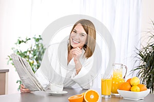 Breakfast - woman reading newspaper in kitchen