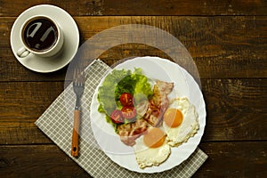 Breakfast on a wooden table. Coffee fried egg with bacon.