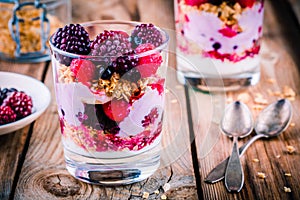 Breakfast: yogurt parfait with granola and raspberry, blueberry, banana and frozen blackberry