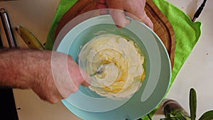 Breaking egg and placing into dish with cream. Stearing together. Overhead, slow motion