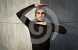 Breaking free from the constraints of society. Young man with calming face showing frame around his head with hands