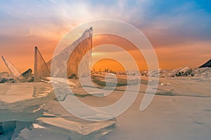 Breaking ice on freezing water lake with after sunset sky, Baikal Russia