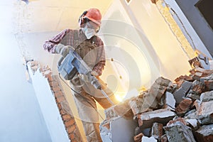 Breaking interior wall. worker with demolition hammer