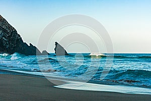 Breaking ocean wave falling down at sunrise time