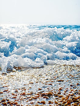 Breaking Wave of Blue Ocean on Pebbles beach Summer Background