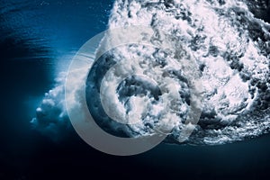 Breaking wave with foam and bubbles underwater. Transparent water