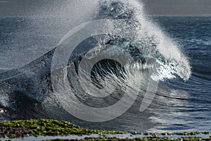 Breaking wave rises up in backwash photo