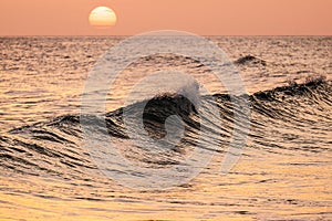 Breaking wave at sunset