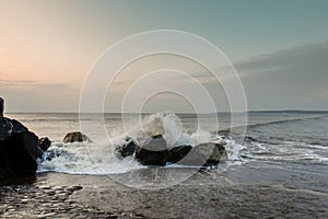 Breaking waves crashing over rocks on the sea shore