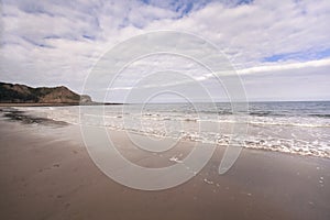 Breaking waves on sandy beach seascape