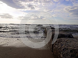 Breaking waves at Westerland beach on Sylt island. National Park Wattenmeer panorama at sunset with colorful cloudy sky