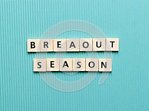 BREAKOUT SEASON text made from square letter tiles