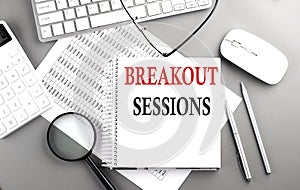 BREAKOUT SESSION text on notepad on chart with keyboard and calculator on grey background