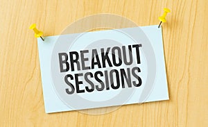 Breakout Sessions sign written on sticky note pinned on wooden wall