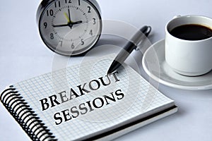 BREAKOUT SESSIONS - words in a notebook on a white background with a clock and a cup of coffee