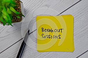 Breakout Sessions write on sticky notes isolated on Wooden Table