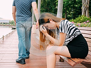 Breakup of a couple with sad girlfriend and boyfriend walking away with city in the background