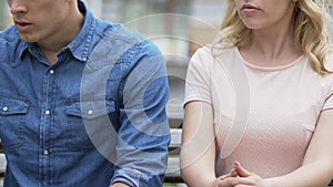 Breakup of young couple, man looking at unfaithful girlfriend and going away