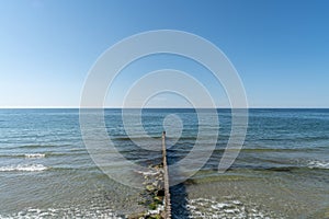 Breakwater on beach. Beautiful seascape. Wooden sea separator. Protection holidaymakers from effects of both weather and longshore photo