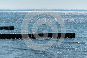 Breakwater on beach. Wooden sea separator. Beautiful seascape. Protection holidaymakers from effects of both weather and longshore photo