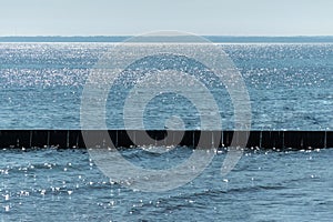 Breakwater on beach. Wooden sea separator. Beautiful seascape. Protection holidaymakers from effects of both weather and longshore photo