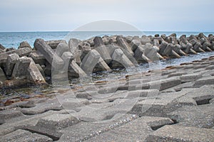 Breakwater coastal protection constructed from prefabricated cement blocks to reduce the intensity of wave action.