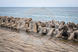 Breakwater coastal protection constructed from prefabricated cement blocks to reduce the intensity of wave action.