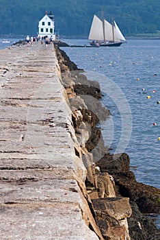 Breakwater Leads to Lighthouse as Schooner Sailing Vessel Passes