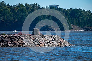 A breakwater made out of granite blocks is sheltering leisure boats in the harbor