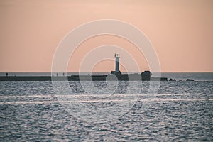 breakwater in the sea with red lighthouse at the end - vintage r