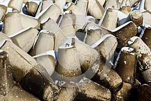 Breakwater tetrapods background with melting snow