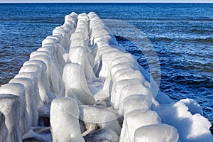 breakwaters covered with ice on a sunny winter day