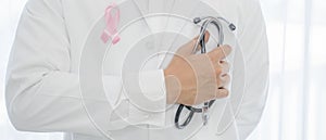 Breast cancer awareness campaign background of doctor in lab coat with stethoscope having breast cancer awareness symbol of pink