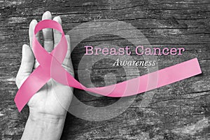 Breast cancer awareness pink ribbon on aged background, satin  bow symbolic concept raising help support on women people living